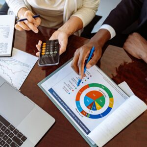 Two business professionals discussing financial documents and strategies at an office desk.